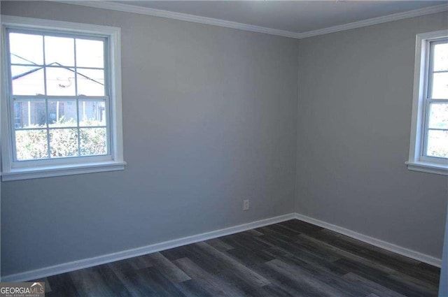 empty room featuring ornamental molding, dark wood-type flooring, plenty of natural light, and baseboards