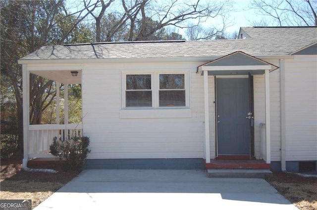 entrance to property with a shingled roof