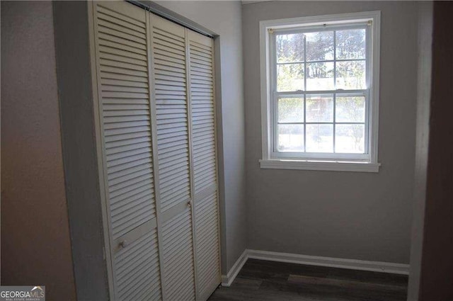 doorway featuring dark wood-style floors and baseboards