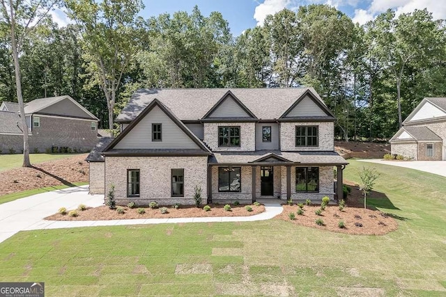 craftsman house with roof with shingles, a front lawn, and brick siding