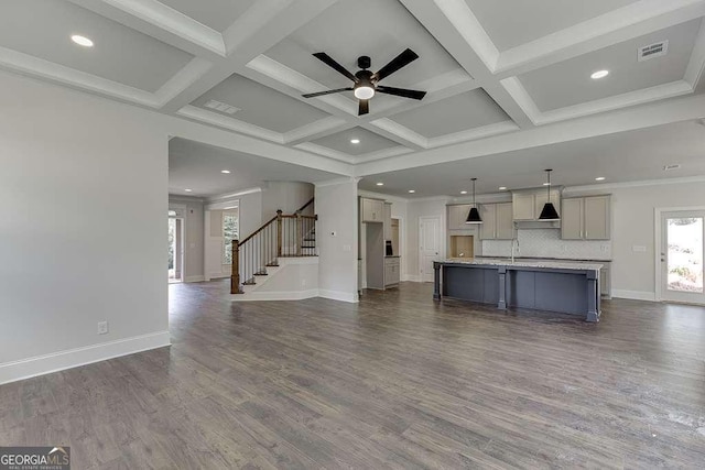 kitchen featuring a kitchen island with sink, coffered ceiling, open floor plan, beam ceiling, and decorative light fixtures