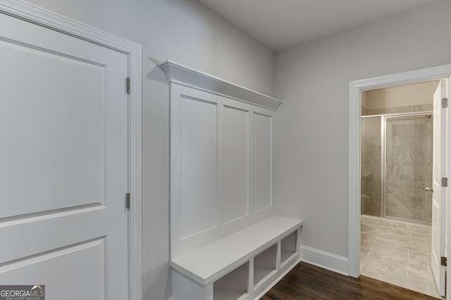 mudroom featuring baseboards and dark wood-type flooring