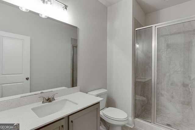 full bathroom featuring a stall shower, vanity, and toilet