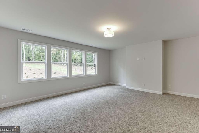 empty room featuring light carpet, baseboards, and visible vents