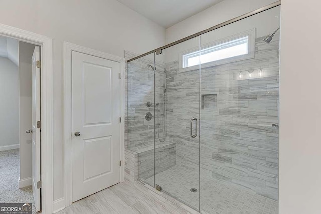 full bath featuring a stall shower and baseboards