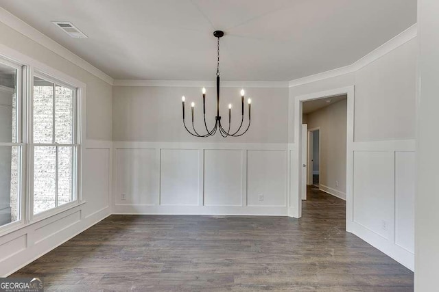 unfurnished dining area featuring dark wood-type flooring, visible vents, a notable chandelier, and a decorative wall