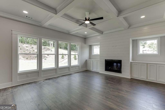 unfurnished living room featuring dark wood-style floors, coffered ceiling, a fireplace, and visible vents