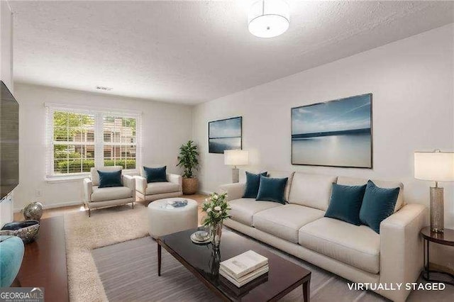 living area featuring a textured ceiling