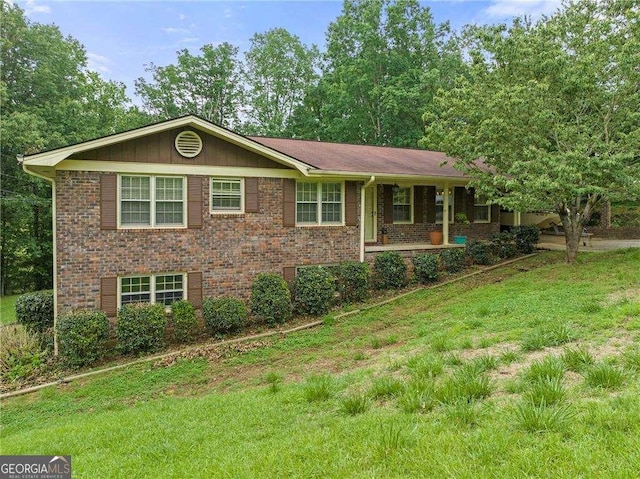 single story home with a front lawn, a porch, and brick siding