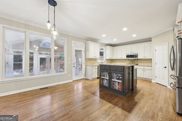 kitchen featuring visible vents, white cabinets, stainless steel appliances, and decorative backsplash