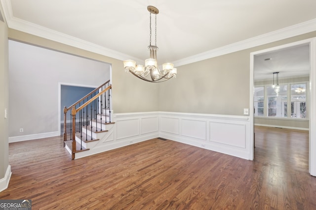 unfurnished dining area with stairway, ornamental molding, and wood finished floors