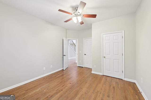 unfurnished bedroom featuring a ceiling fan, light wood-style floors, and baseboards