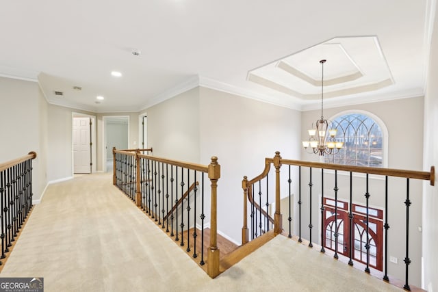 hallway featuring baseboards, ornamental molding, an upstairs landing, carpet flooring, and an inviting chandelier