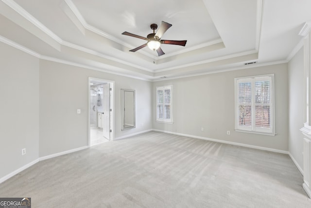 unfurnished room with visible vents, light colored carpet, a raised ceiling, and baseboards