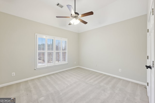 spare room featuring light carpet, visible vents, and baseboards