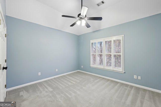 spare room with visible vents, light colored carpet, baseboards, and ceiling fan