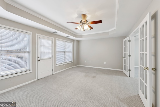 spare room with carpet flooring, french doors, a raised ceiling, and baseboards