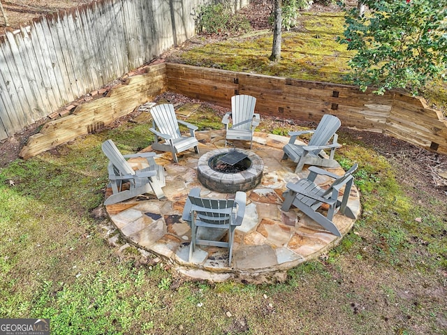 exterior space featuring an outdoor fire pit and a fenced backyard