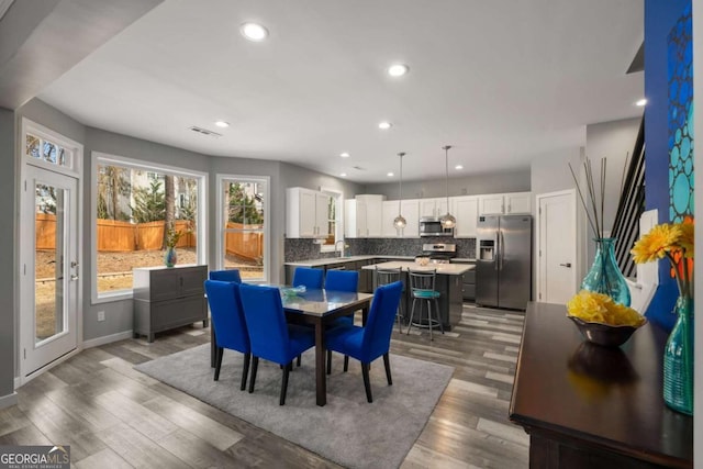 dining space featuring dark wood-style floors, baseboards, visible vents, and recessed lighting