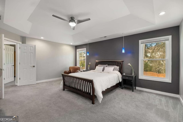 bedroom featuring ceiling fan, recessed lighting, light carpet, baseboards, and a raised ceiling