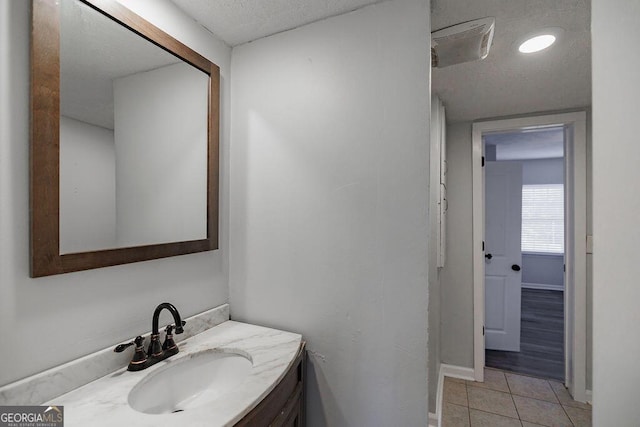 bathroom with vanity, baseboards, and tile patterned floors