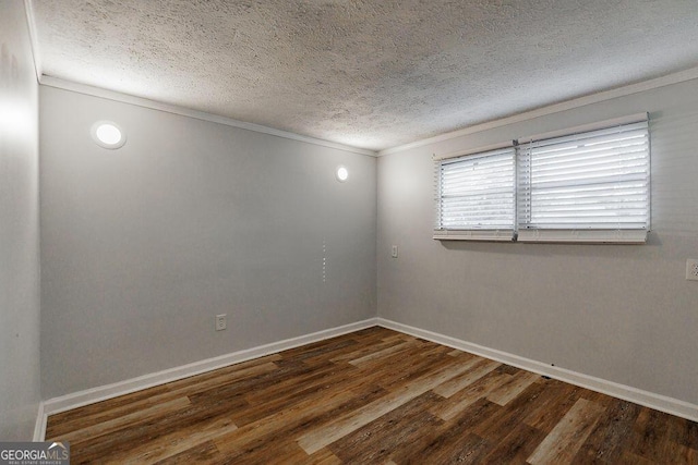 empty room featuring baseboards, dark wood finished floors, a textured ceiling, and ornamental molding