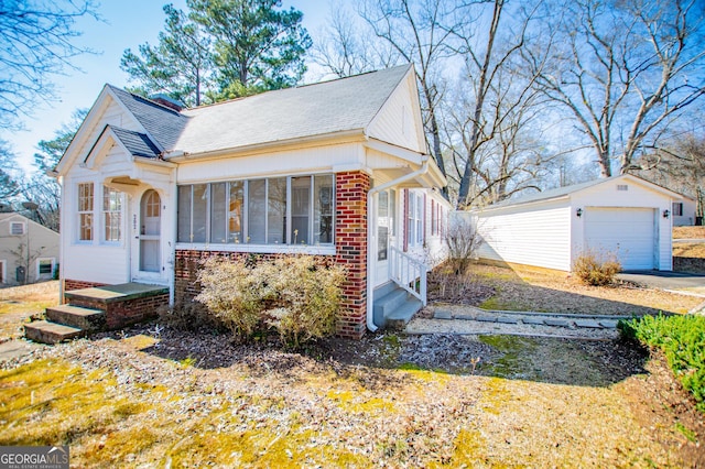 view of front of property with entry steps, a detached garage, an outdoor structure, and brick siding