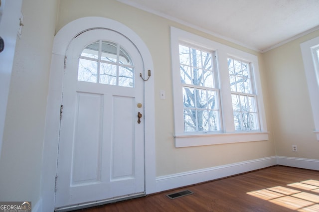 entrance foyer featuring dark wood-style flooring, visible vents, crown molding, and baseboards