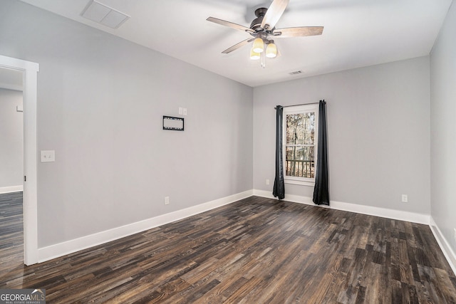 spare room featuring dark wood finished floors, visible vents, ceiling fan, and baseboards