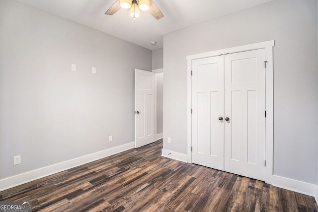 unfurnished bedroom featuring ceiling fan, a closet, baseboards, and dark wood-type flooring