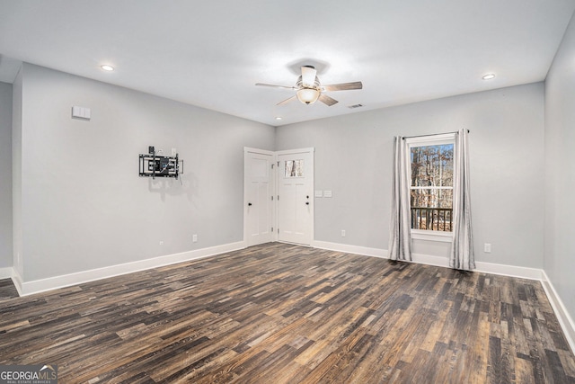 unfurnished room featuring ceiling fan, visible vents, baseboards, and dark wood-type flooring