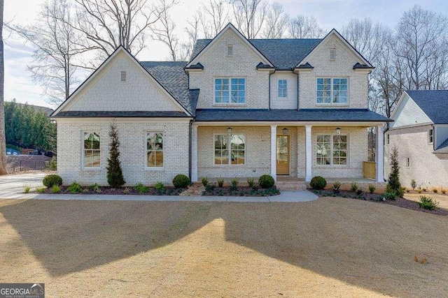 view of front facade featuring covered porch and brick siding