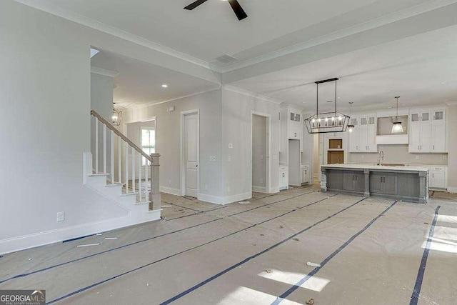 unfurnished living room featuring stairs, baseboards, crown molding, and ceiling fan with notable chandelier