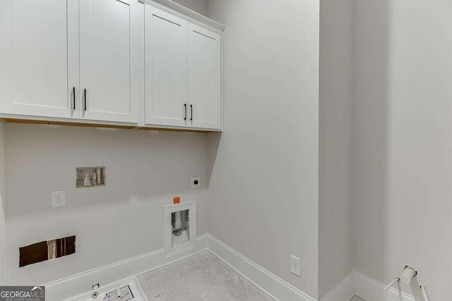 laundry area with gas dryer hookup, cabinet space, baseboards, and electric dryer hookup