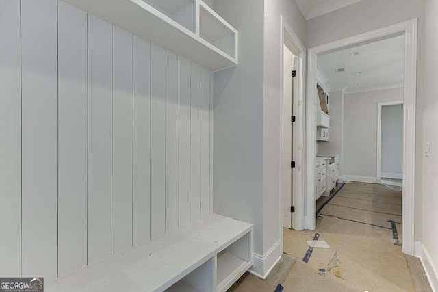 mudroom with ornamental molding and baseboards