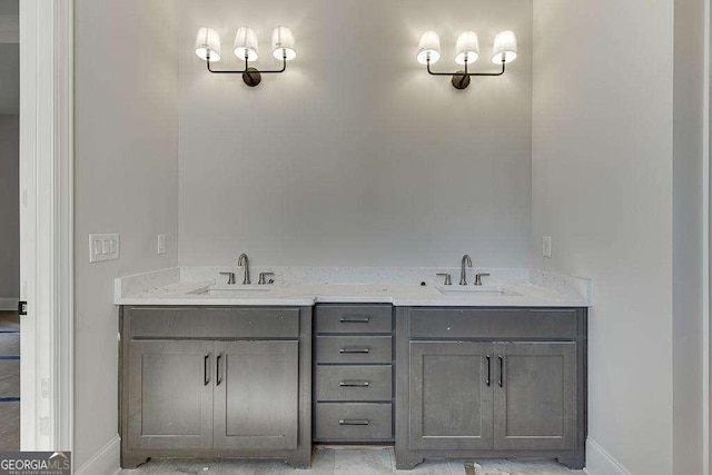 bathroom with double vanity, a sink, and baseboards