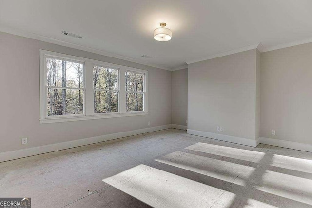 empty room with baseboards, visible vents, and crown molding