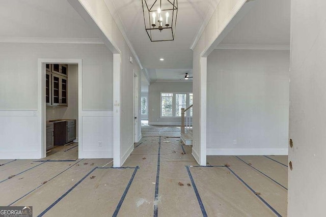 foyer featuring ornamental molding, an inviting chandelier, baseboards, and stairs