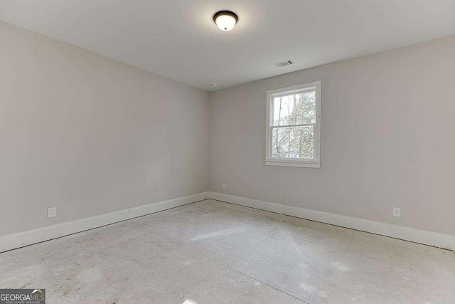 unfurnished room featuring visible vents, concrete floors, and baseboards