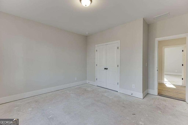 unfurnished bedroom featuring a closet, visible vents, and baseboards