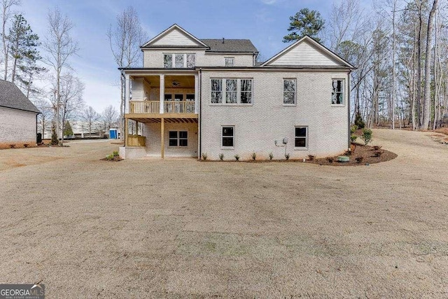 rear view of property with a balcony and brick siding