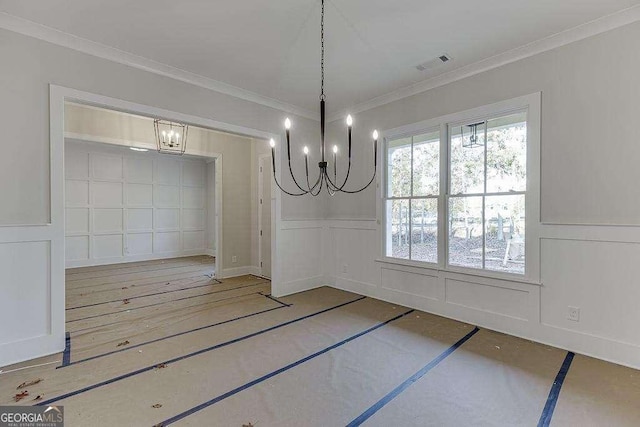 unfurnished dining area with a wainscoted wall, visible vents, a decorative wall, and crown molding