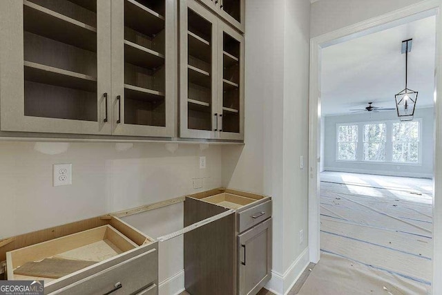 kitchen featuring glass insert cabinets, decorative light fixtures, and a ceiling fan