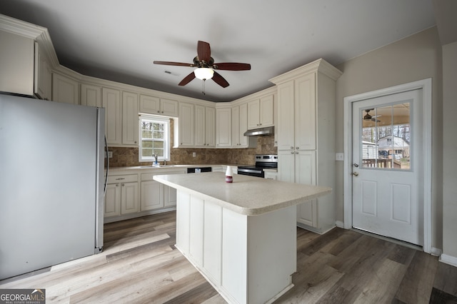 2820 Maxwell Pl, Lithia Springs, GA 30122 - kitchen with under cabinet range hood, stainless steel appliances, light countertops, and a ceiling fan