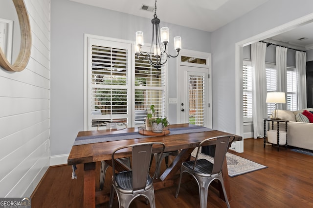 dining area featuring baseboards, wood finished floors, visible vents, and an inviting chandelier