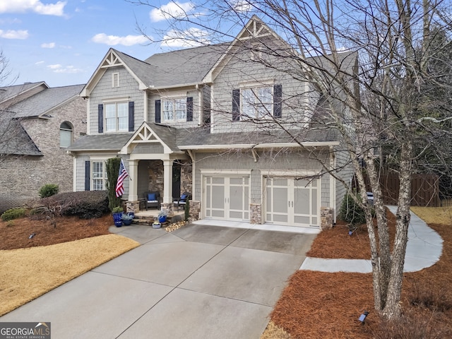 view of front of house featuring driveway, stone siding, and a garage