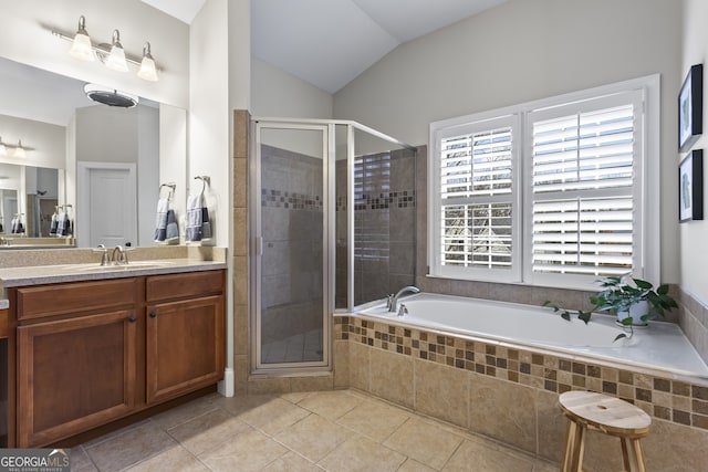 bathroom with a stall shower, vaulted ceiling, a garden tub, and vanity