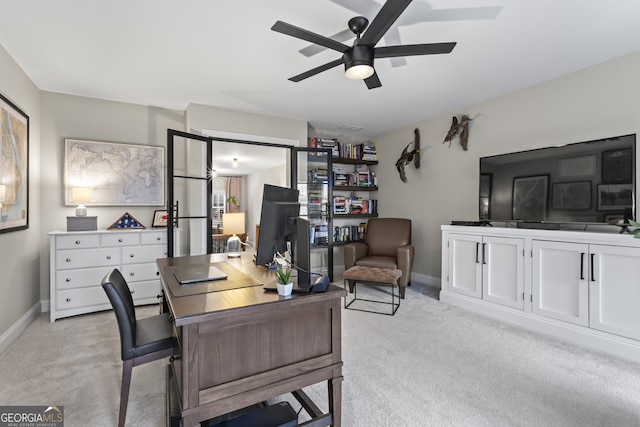 office space with ceiling fan, baseboards, and light colored carpet