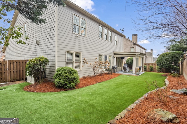 back of property with a patio area, a fenced backyard, and a yard