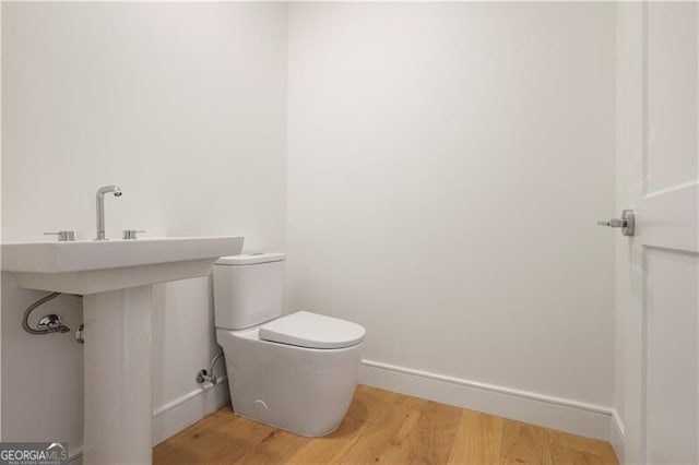 2425 Peachtree Rd NE Unit 903, Atlanta, GA 30305 - half bathroom featuring toilet, wood finished floors, and baseboards